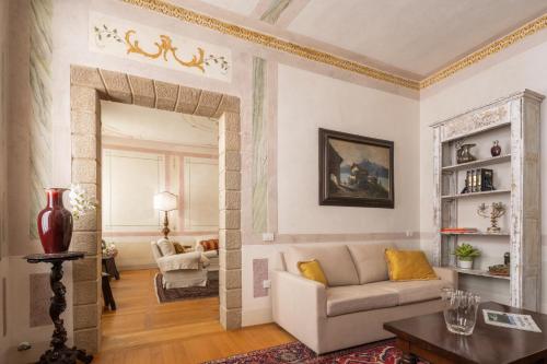 a living room with a couch and a table at Palazzo Benassi Nobile Dimora nel Cuore di Asolo in Asolo