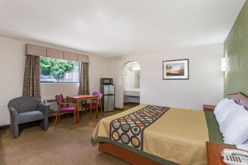 a hotel room with a bed and a table and chairs at Knights Inn Franklin Ave Waco in Waco