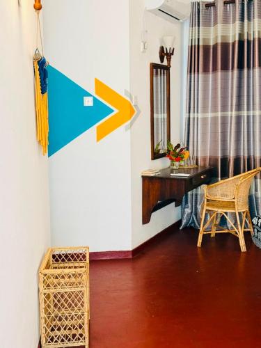 a room with an arrow on the wall and a desk at Dickwella Beach in Dickwella