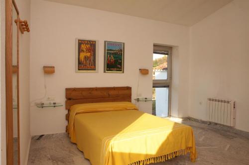 a bedroom with a bed with a yellow bedspread at Casa de las Letrinas Alta, 2 Habt 5 más 1 Pers max chimenea con horno in Puerto de la Laja