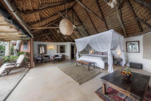 a bedroom in a villa with a bed and a table at Elewana Elsa's Kopje in Meru