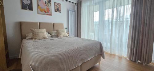 a bedroom with a bed and a large window at Studio S23 in Piatra Neamţ