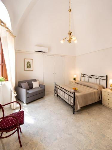 a bedroom with a bed and a couch and a chair at La Dimora del Colle in Mottola