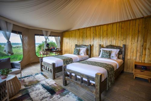 a bedroom with two beds in a tent at Malaika Ndutu Luxury Camp in Sinoni