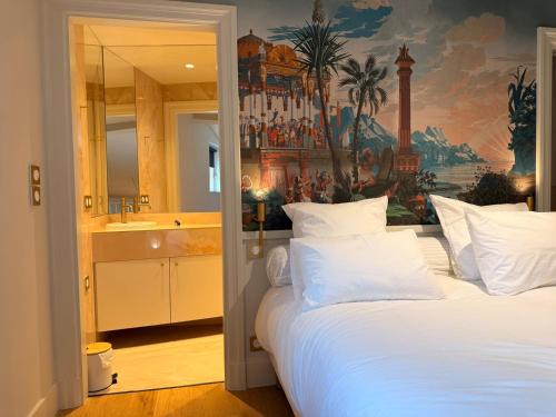 a bedroom with a large white bed and a bathroom at Duplex charmant dans le centre - La suite Incas in Le Puy-en-Velay
