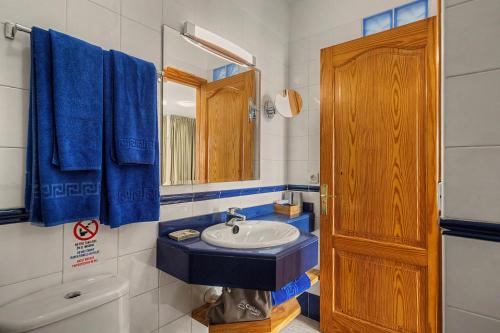 a bathroom with a sink and a mirror and blue towels at Callao Beach 2 in Arrieta