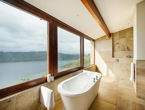 a bath tub in a bathroom with a large window at Cloud 9 Luxury Eco Villa in Sedgefield