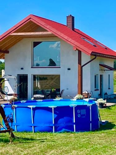 a house with a swimming pool in front of it at Spokojna Dolina in Brejdyny