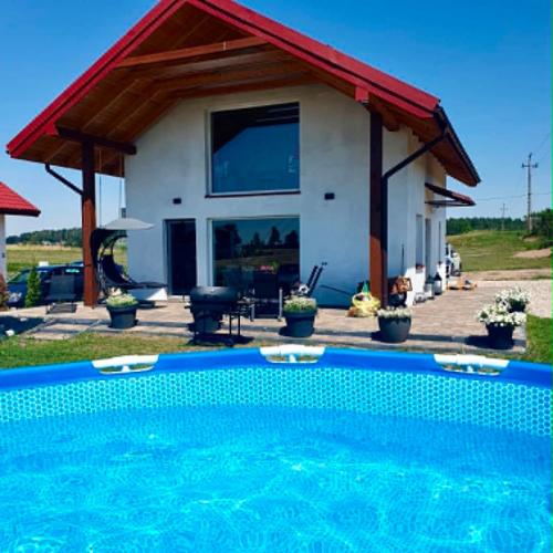 a house with a swimming pool in front of it at Spokojna Dolina in Brejdyny