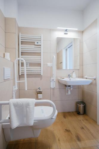 a bathroom with a sink and a toilet and a mirror at APARTHOTEL Wałcz in Wałcz