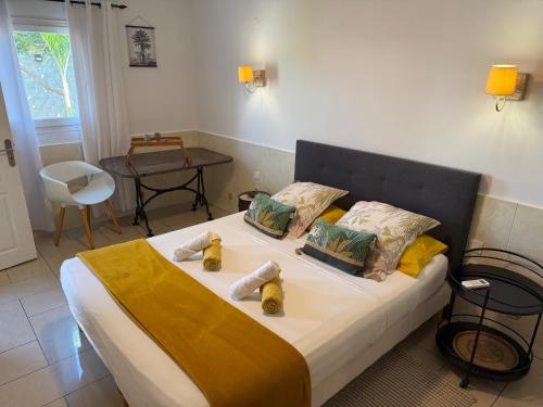 a bedroom with a bed with towels on it at Bungalow Les Coraux in La Saline les Bains