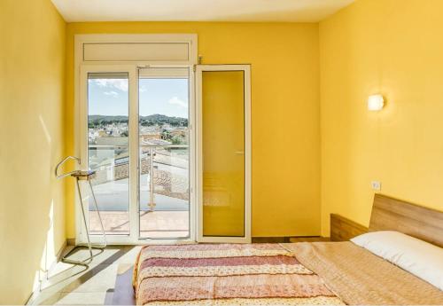 a yellow room with a bed and a balcony at Escala Riells in L'Escala