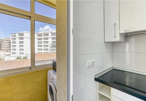 a kitchen with white walls and a window at Escala Riells in L'Escala