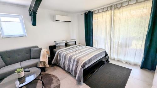 a bedroom with a bed and a couch at Tranquillity in a modern unit in Bazugues