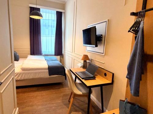a hotel room with a desk with a laptop on it at UNO Smart Hamburg Central 056 in Hamburg