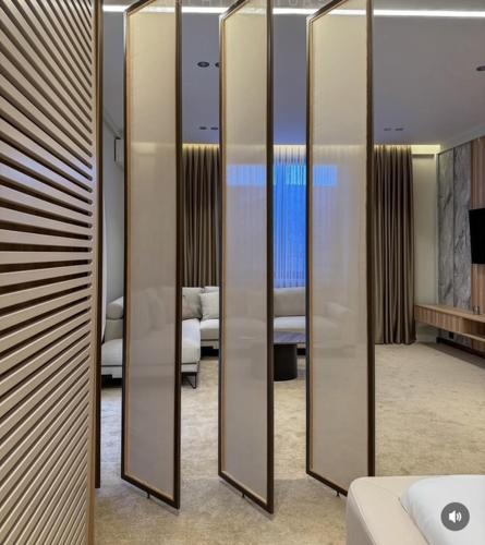 a row of mirrors in a room with a bed at Vatër by the lake in Shirokë