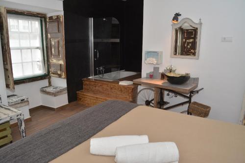 bagno con vasca, tavolo e lavandino di Lovin Book Guesthouse a Óbidos