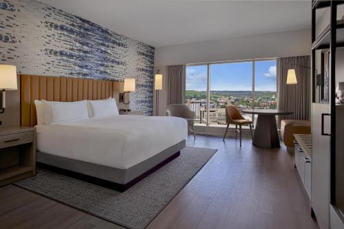 a hotel room with a large bed and a table at DoubleTree by Hilton Hotel Cedar Rapids Convention Complex in Cedar Rapids