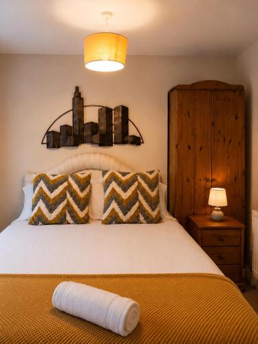 a bedroom with a large bed with a yellow blanket at 54 - Room 2 - Smart Tv in Swansea