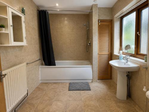 a bathroom with a bath tub and a sink at 54 - Room 2 - Smart Tv in Swansea