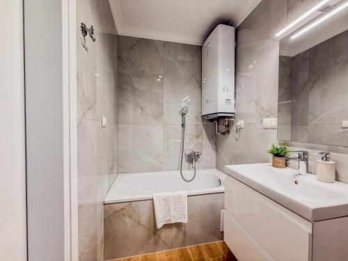a bathroom with a white tub and a sink at Apartament Biłgorajski przy Rynku in Biłgoraj
