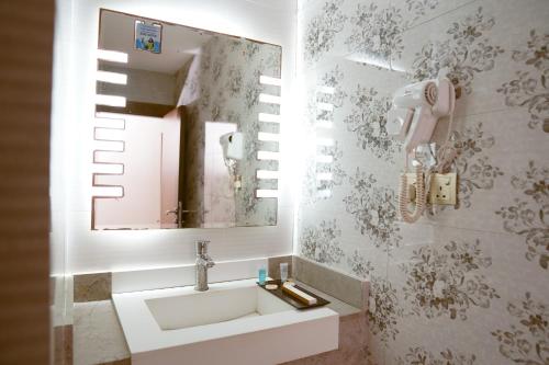 a bathroom with a sink and a mirror at فندق فربيون المجاردة - Ferbion Hotel Almajardah in Al Majaridah