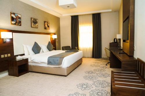 a hotel room with a bed and a desk at فندق فربيون المجاردة - Ferbion Hotel Almajardah in Al Majaridah