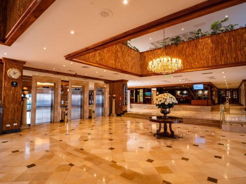 a lobby with a vase of flowers on a table at Swissotel Quito in Quito