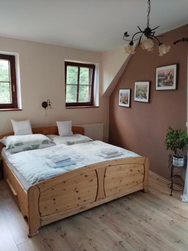 a bedroom with a large wooden bed in a room at Penzion Farma Dolík in Havlíčkŭv Brod