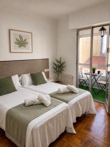 a bedroom with two beds with towels on them at Apartamentos Campus Arzúa in Arzúa