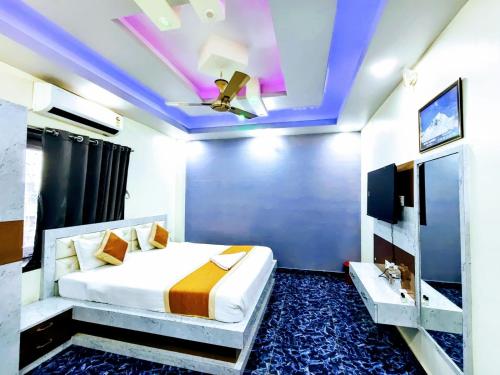 a bedroom with a bed and a ceiling fan at Hotel Glacier in Arāria