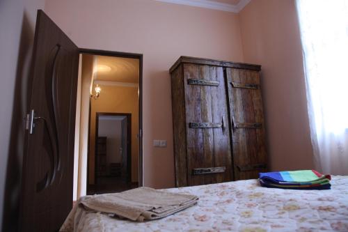 a bedroom with a bed and a wooden cabinet at Guest house Dilijan Orran in Dilijan