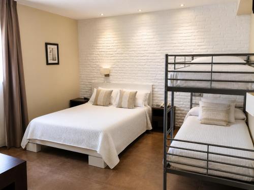 a bedroom with two beds and a bunk bed at Hotel Restaurante El Corte in Casabermeja