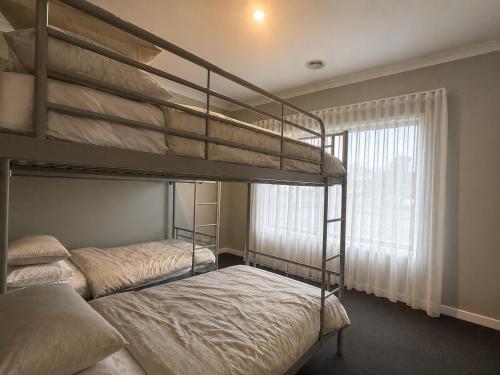 two bunk beds in a room with a window at Central 3BR Home in Mansfield