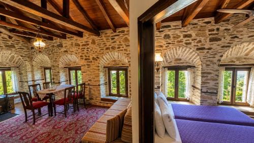 a room with a bed and a table and chairs at Archontiko Michael Pelion in Vyzitsa