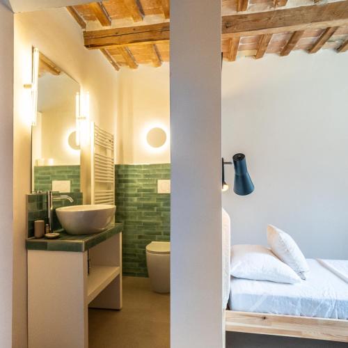 a bathroom with a bed and a sink in a room at Rifugio Vita Luminosa in Montecarotto