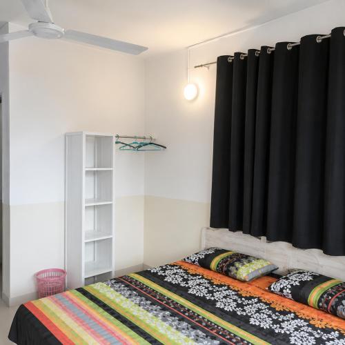 ein Schlafzimmer mit einem Bett und einem schwarzen Vorhang in der Unterkunft Brise de Mer Sun in Dschibuti
