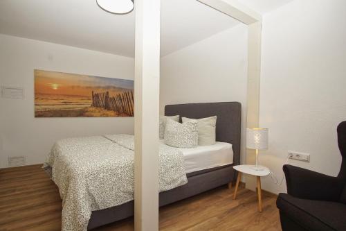 a bedroom with a bed and a painting on the wall at Ferienwohnung Irmchen in Altefähr