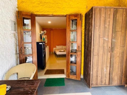a room with a door open to a kitchen with a refrigerator at Nina's Aqua - Private Pool Villa & Plunge Pool Studios, Anjuna in Anjuna