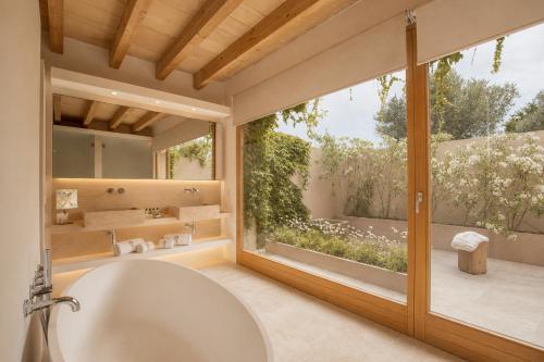 a bathroom with a tub and a large window at Fontsanta Hotel Thermal & Spa - Adults Only in Colònia de Sant Jordi
