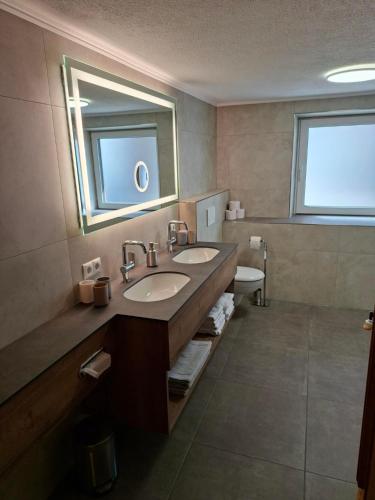 a bathroom with two sinks and a mirror at Landhaus Gollner in Uderns