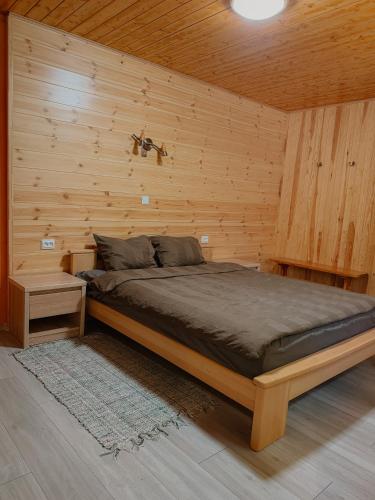 a bedroom with a bed in a wooden wall at Ligzdiņas in Bernāti