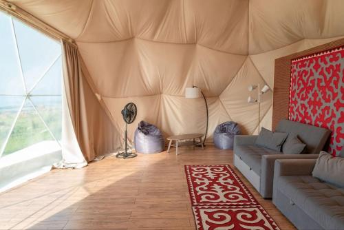 a living room with a couch in a tent at Old stones glamping in Chok-Tal