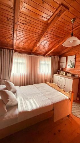 a large bed in a room with a wooden ceiling at Mountain Paradise House in Žabljak