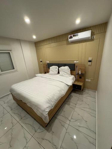 a bedroom with a large bed with marble flooring at Le Conviviall in Yaoundé