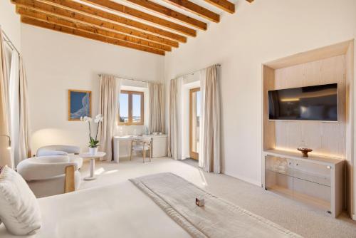 a white room with a bed and a tv at Fontsanta Hotel Thermal & Spa - Adults Only in Colònia de Sant Jordi