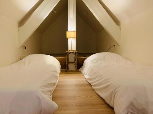two beds in a room with a attic at De Lotuspoort met Mihr's rustplek in de Abdij van Bornem in Bornem