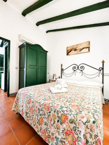 a bedroom with a bed and a green cabinet at Villas El Cañuelo in Monturque