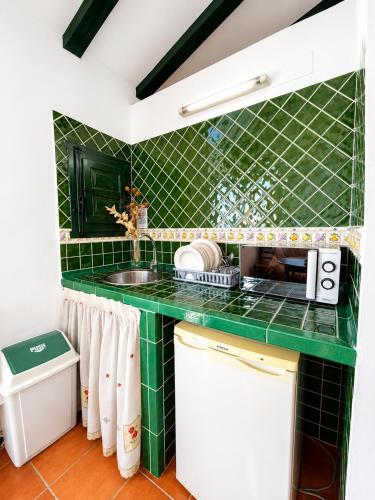 a green tiled kitchen with a sink at Villas El Cañuelo in Monturque