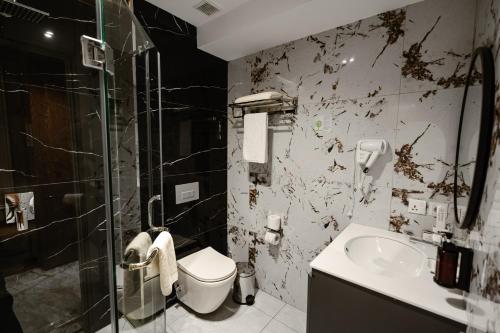a dirty bathroom with a toilet and a sink at Meridian Plaza by Reikartz in Samarkand